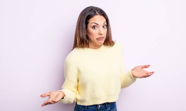 pretty hispanic woman feeling clueless and confused, having no idea, absolutely puzzled with a dumb or foolish look