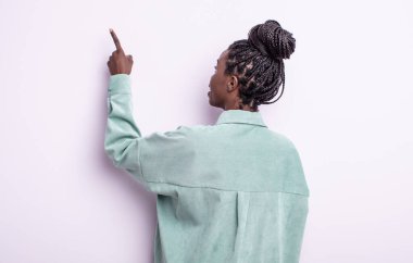 Siyah güzel kadın dikiz aynasında duran ve objeye işaret eden