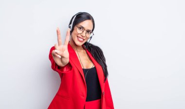 Güzel İspanyol kadın gülümsüyor ve arkadaş canlısı görünüyor, iki numarayı gösteriyor. tele pazarlama kavramı