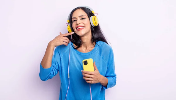 自信を持って笑顔で笑顔を見せるパニック系の女性 スマートフォンとヘッドフォンのコンセプト — ストック写真