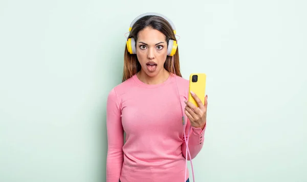 Pretty Hispanic Woman Looking Very Shocked Surprised Smartphone Headphones Concept — Stock Photo, Image