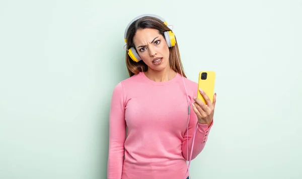 Mujer Bastante Hispana Sintiéndose Desconcertada Confundida Concepto Smartphone Auriculares —  Fotos de Stock