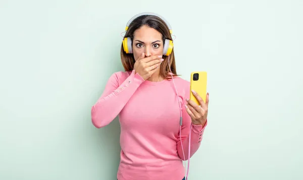 Pretty Hispanic Woman Covering Mouth Hands Shocked Smartphone Headphones Concept — Stock Photo, Image