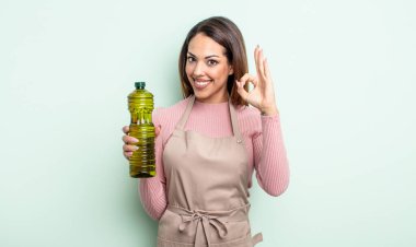 Güzel İspanyol bir kadın kendini mutlu hissediyor, iyi bir jestle onaylıyor. Zeytin yağı kavramı