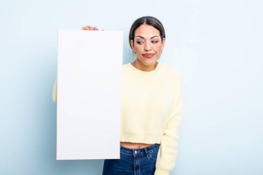 Güzel İspanyol bir kadın omuz silkiyor, kafası karışık ve kararsız hissediyor. boş alan kavramı