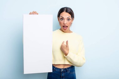 Şok olmuş ve ağzı açık, kendini işaret eden güzel İspanyol bir kadın. boş alan kavramı