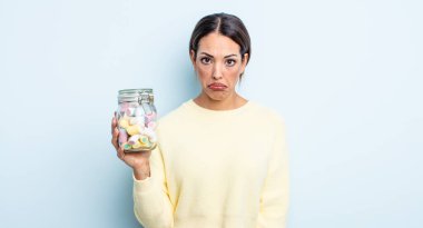 Güzel İspanyol bir kadın üzgün ve mızmızlanıyor. Mutsuz bir bakışı var ve ağlıyor. jöle şekeri konsepti