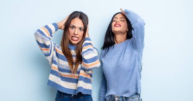 Oldukça İspanyol bir kadın stresli, endişeli ya da korkmuş, elleri başının üstünde. bir çift arkadaş kavramı