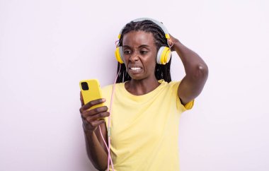 Güzel siyah kadın stresli, endişeli ya da korkmuş hissediyor, elleri başının üstünde. müzik konseptini dinlemek