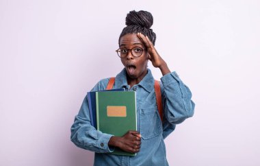 Güzel siyah kadın mutlu, şaşkın ve şaşırmış görünüyor. Kitap konsepti olan öğrenci