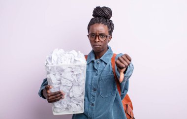 Güzel siyahi kadın kızgın hissediyor, baş parmağını kaldırıyor. kağıt toplar başarısızlık konsepti