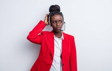 Güzel siyah kadın şaşkın ve kafası karışık, kaşınan bir kafa hissediyor. tele pazarlama kavramı