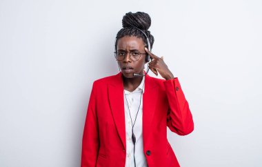 Güzel siyah kadın kafası karışık ve şaşkın hissediyor, deli olduğunu gösteriyor. tele pazarlama kavramı