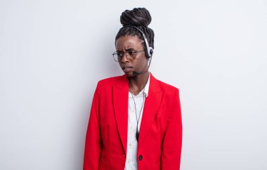 Güzel siyah kadın üzgün, üzgün ya da kızgın hissediyor ve yan tarafa bakıyor. tele pazarlama kavramı