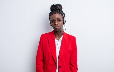 Güzel siyah bir kadın üzgün ve mızmızlanıyor. Mutsuz bir bakışı var ve ağlıyor. tele pazarlama kavramı