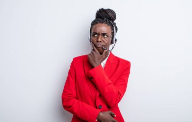 Güzel siyah kadın düşünüyor, kuşkulu ve şaşkın hissediyor. tele pazarlama kavramı