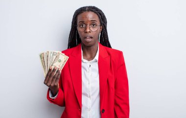 Güzel siyah kadın çok şaşırmış ya da şaşkın görünüyor. Dolar banknotları konsepti