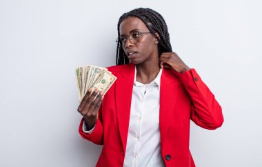 Güzel siyah kadın stresli, endişeli, yorgun ve hayal kırıklığına uğramış hissediyor. Dolar banknotları konsepti