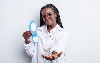 Güzel siyah kadın mutlu bir şekilde gülümsüyor ve bir konsept sunuyor. podiatrist kavramı