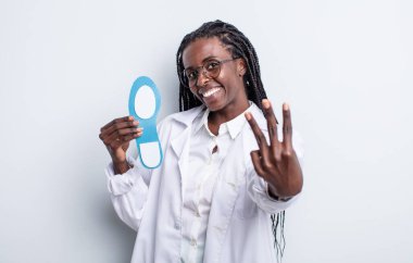 Güzel siyah kadın gülümsüyor ve arkadaş canlısı görünüyor, üç numarayı gösteriyor. podiatrist kavramı