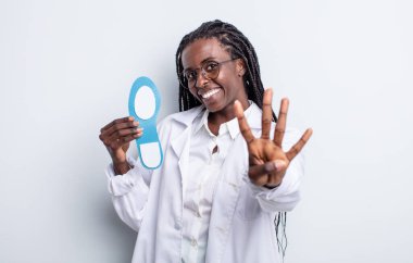 Güzel siyah kadın gülümsüyor ve arkadaş canlısı görünüyor, dört numarayı gösteriyor. podiatrist kavramı