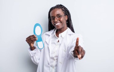 Güzel siyah kadın gururla gülümsüyor ve kendinden emin bir numara oluyor. podiatrist kavramı