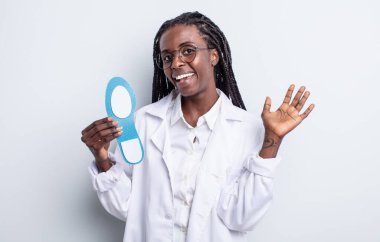 Güzel siyah kadın mutlu bir şekilde gülümsüyor, el sallıyor, hoş karşılıyor ve seni selamlıyor. podiatrist kavramı