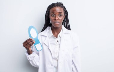 Güzel siyah kadın şaşkın ve şaşkın görünüyor. podiatrist kavramı