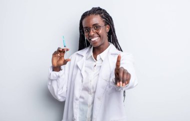 Güzel siyah kadın gururla gülümsüyor ve kendinden emin bir numara oluyor. Sryinge konsepti