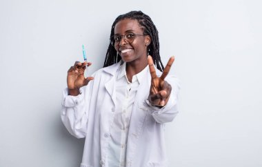 Güzel siyah kadın gülümsüyor ve arkadaş canlısı görünüyor, iki numarayı gösteriyor. Sryinge konsepti