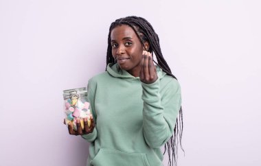 Güzel siyah kadın kapiş ya da para hareketi yapıyor, sana ödemeni söylüyor. jöle şekeri konsepti