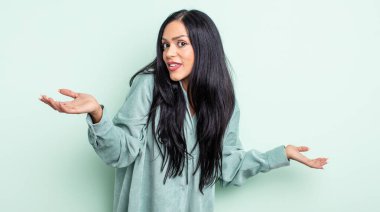 Şaşkın, kafası karışmış ve stresli görünen İspanyol bir kadın. Farklı seçenekler arasında merak ediyor. Belirsiz hissediyor.