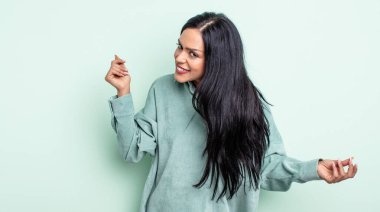 Güzel İspanyol kadın gülümsüyor, kaygısız hissediyor, rahat ve mutlu, dans ediyor ve müzik dinliyor, bir partide eğleniyor.