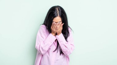 Güzel İspanyol bir kadın üzgün, hayal kırıklığına uğramış, gergin ve depresif, iki eliyle yüzünü kaplayan, ağlayan