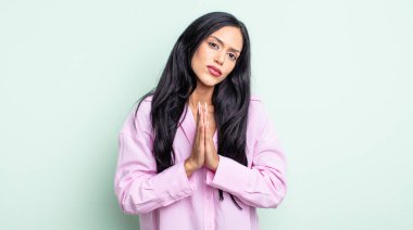 Güzel İspanyol bir kadın endişeli, umutlu ve dindar hissediyor, avuçlarına bastırılmış, af dileyen, sadakatle dua ediyor.