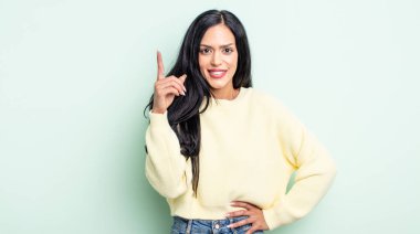 Güzel İspanyol kadın mutlu bir şekilde gülümsüyor, tek eliyle uzayı işaret ediyor.