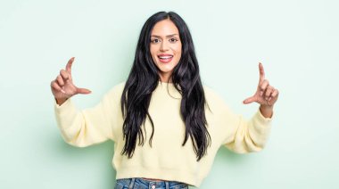 Güzel, İspanyol bir kadın kendi gülüşünü çiziyor, iki eliyle, olumlu ve mutlu görünüyor, sağIık kavramı.