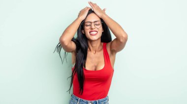 Güzel İspanyol bir kadın stresli ve endişeli, depresif ve hayal kırıklığına uğramış hissediyor, iki elini de başa kaldırıyor.