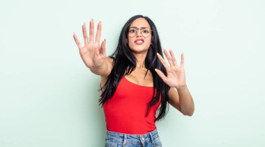 Tatlı İspanyol kadın korkmuş, geri çekiliyor ve korku ve panik içinde bağırıyor, bir kabusa tepki veriyor.