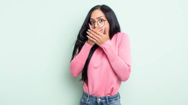 Güzel İspanyol kadın elleri ile ağzını kapatıyor, şok olmuş, şaşırmış bir ifadeyle, sır saklıyor ya da 