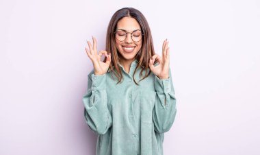 Güzel İspanyol bir kadın konsantre olmuş ve meditasyon yapıyor, tatmin olmuş ve rahatlamış hissediyor, düşünüyor ya da bir seçim yapıyor.