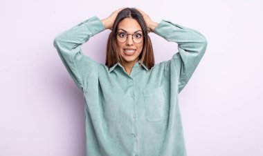 Güzel İspanyol bir kadın kendini stresli, endişeli, endişeli ya da korkmuş hissediyordu. Elleri başının üstünde, hatayla panikliyordu.