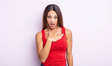 Güzel İspanyol kadın şaşkın, şaşkın ve şaşırmış hissediyor, elleri göğsünde ve ağzı açık, kim olduğunu söylüyor, ben mi??