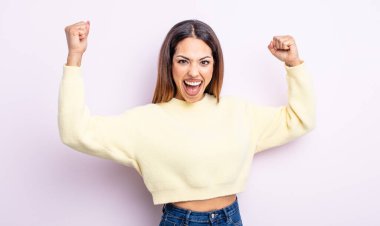 Güzel İspanyol kadın muzaffer bir şekilde bağırıyor, heyecanlı, mutlu ve şaşırmış görünüyor, kutlama yapıyor.