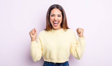 Güzel İspanyol bir kadın mutlu, şaşırmış ve gururlanmış hissediyor, bağırıyor ve başarıyı büyük bir gülümsemeyle kutluyor.