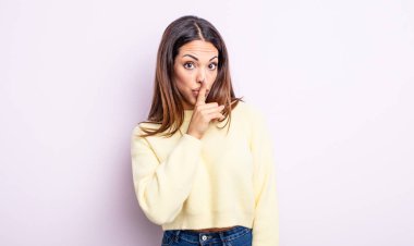 Güzel İspanyol bir kadın sessizlik ve sessizlik istiyor, parmaklarıyla ağzının önünde işaret ediyor, 