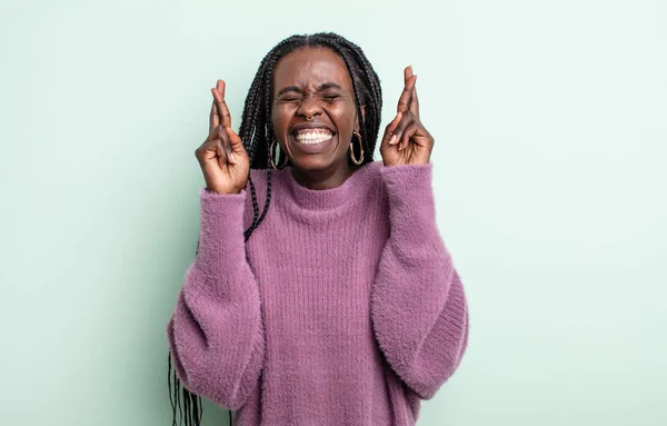 Mujer Bonita Negra Sonriendo Ansiosamente Cruzando Ambos Dedos Sintiéndose Preocupada —  Fotos de Stock