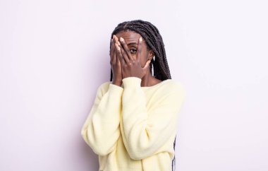 Siyah, güzel bir kadın korkmuş ya da utanmış hissediyor. Gözleri yarı kapalı ya da elleri kapalı dikizliyor ya da dikizliyor.