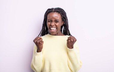 Siyahi güzel kadın zaferle bağırıyor, gülüyor, mutlu ve heyecanlı hissediyor başarıyı kutlarken.