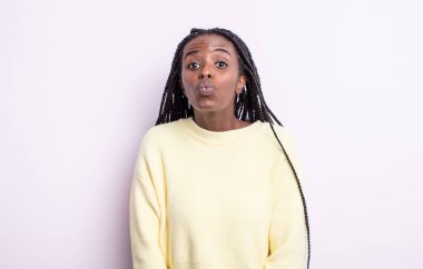 Tatlı, eğlenceli, mutlu, sevimli bir yüz ifadesiyle dudaklarını birbirine bastıran siyah, güzel bir kadın. Öpücük gönderiyor.